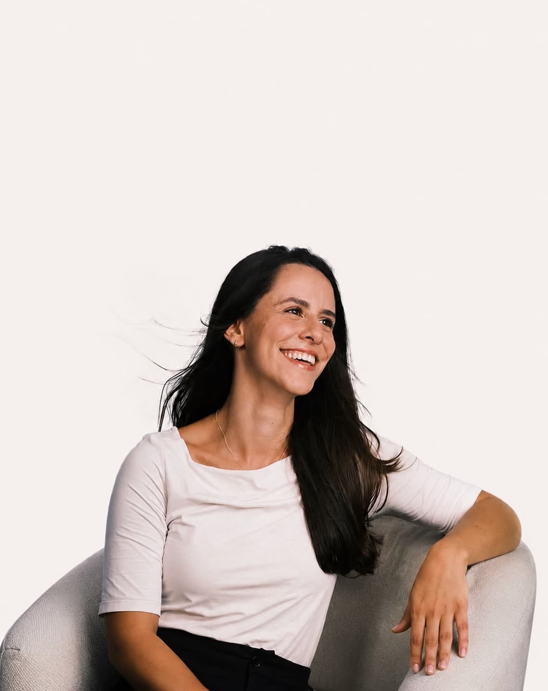 Bianca Czeszak, fisioterapeuta infantil, sorrindo sentada em uma poltrona